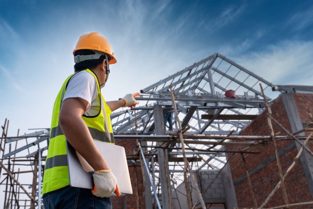 Engineer technician Looking Up roof structure and Analyzing an Unfinished Construction Project