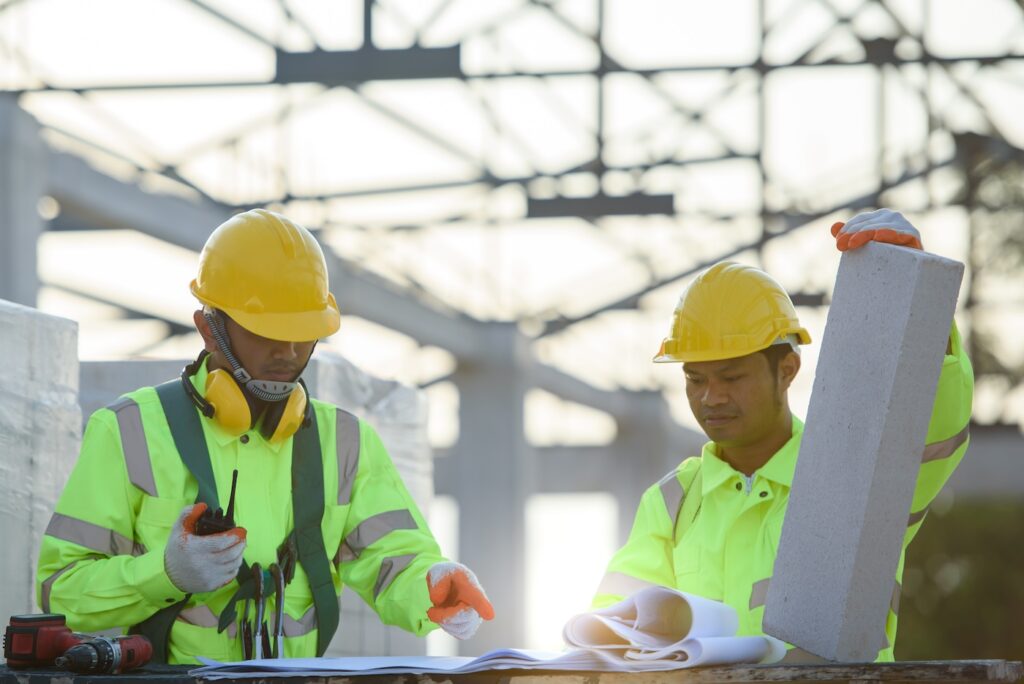Engineers and construction workers wear safety clothing and safety harnesses. Looking at the structural design at the construction site