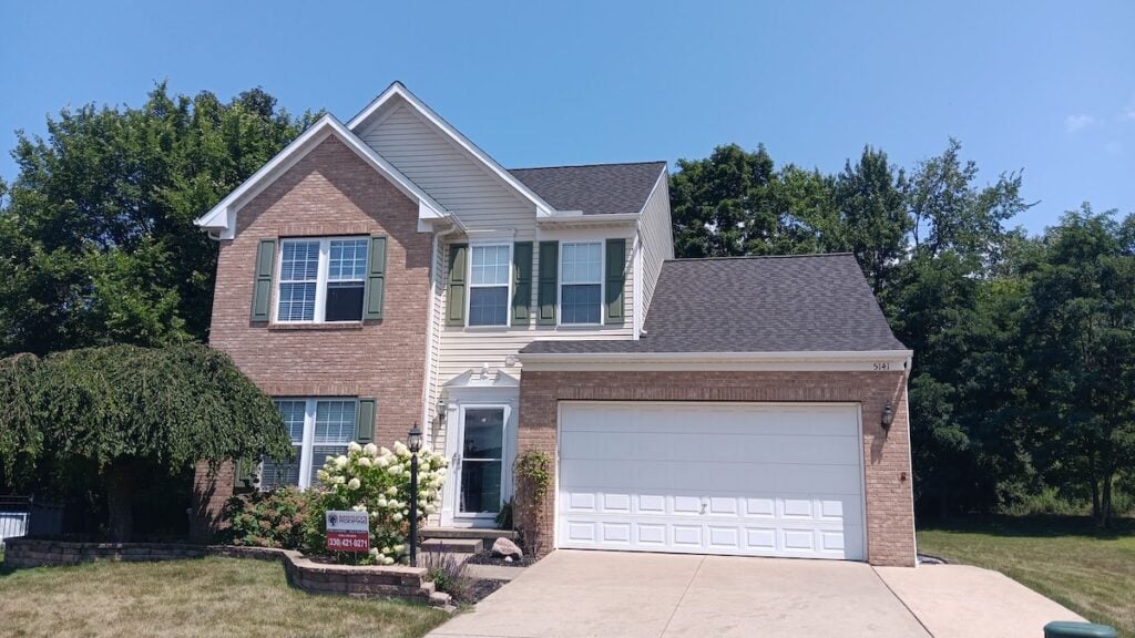 Family house with attached garage, brick and gray roof