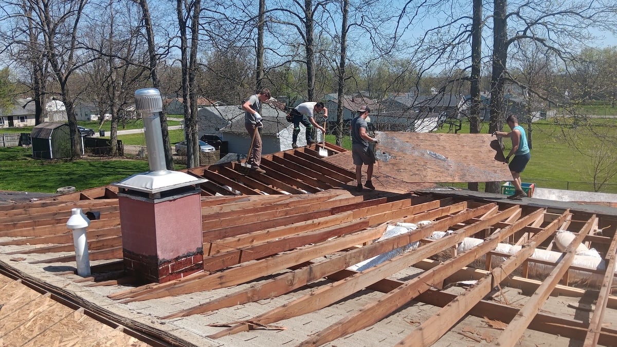 Storm damage water damaged wood being taken off of roof
