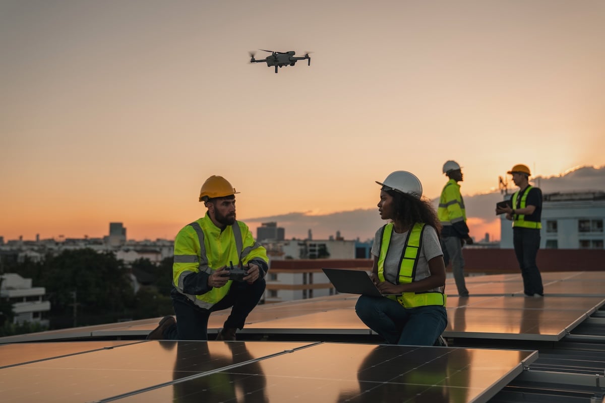 Service engineer checking roof for damage with a drone