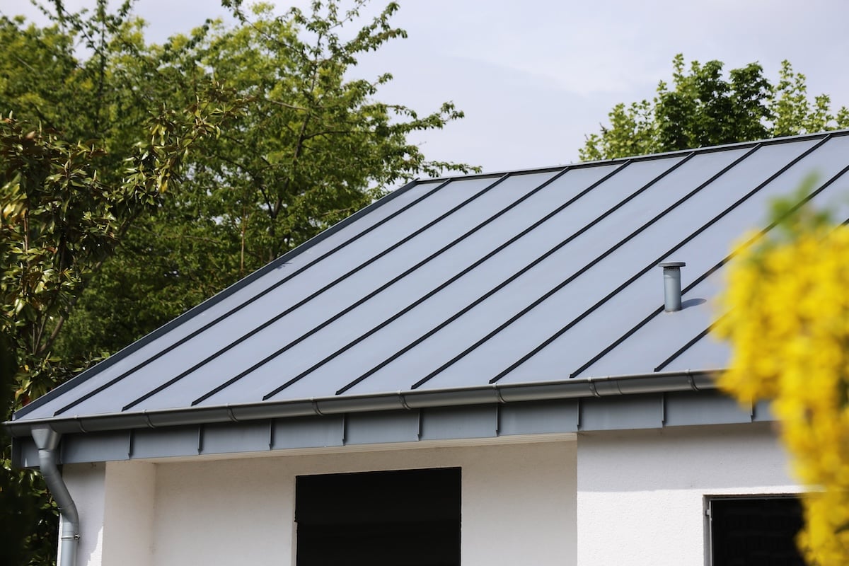 metal standing seam roof black on white house