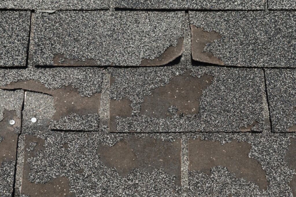 Roof in need of repair damaged asphalt roofing shingles