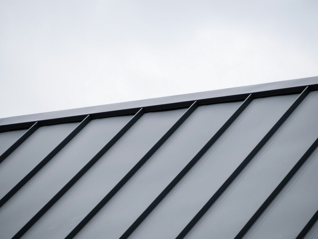 Modern Tray Metal Roof with Black Standing Seam Panels Against Cloudy Sky