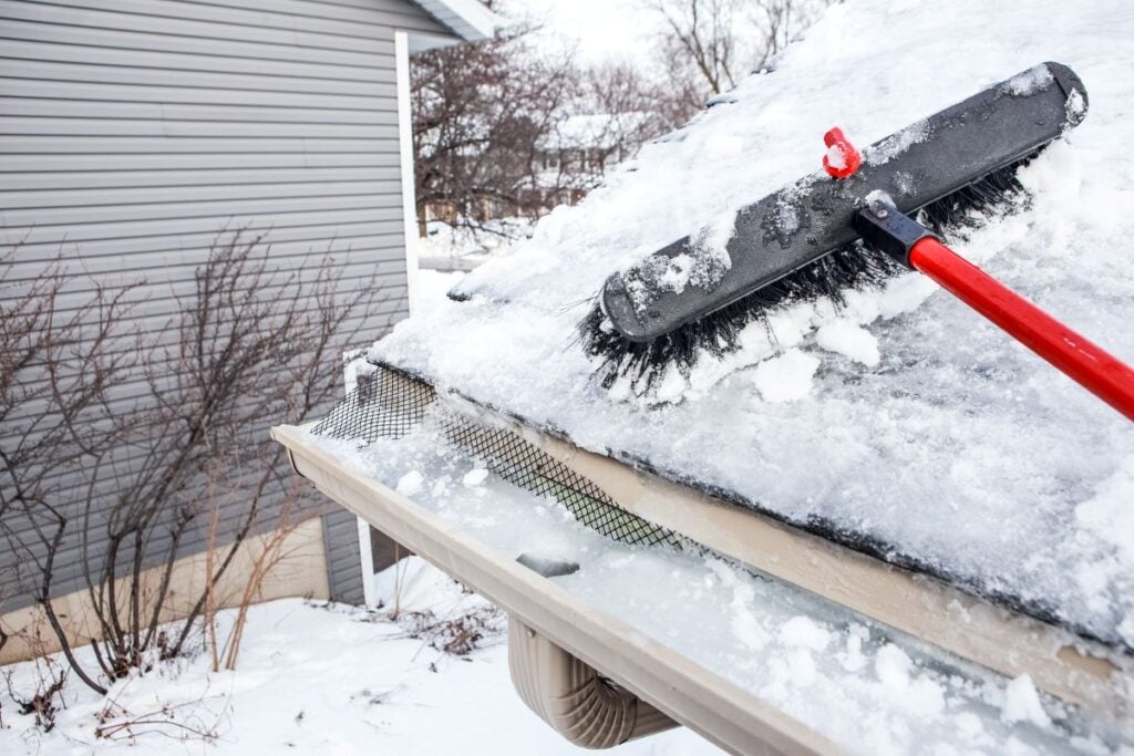 how to prevent ice dams broom removing snow on roof