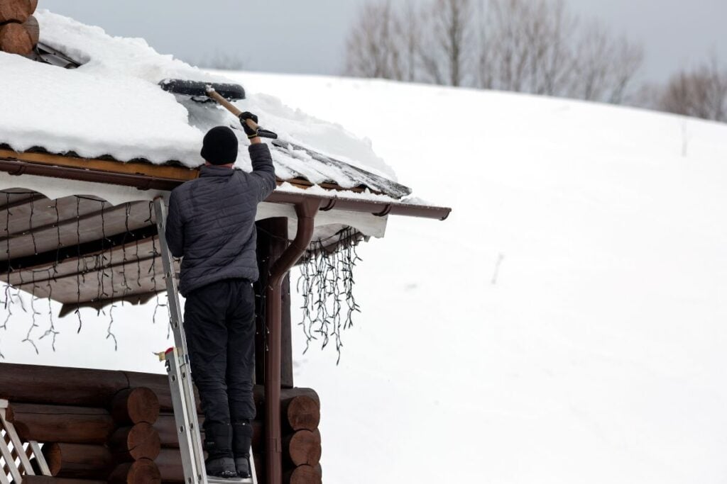 ice dam removal brunswick oh worker removing snow on roof