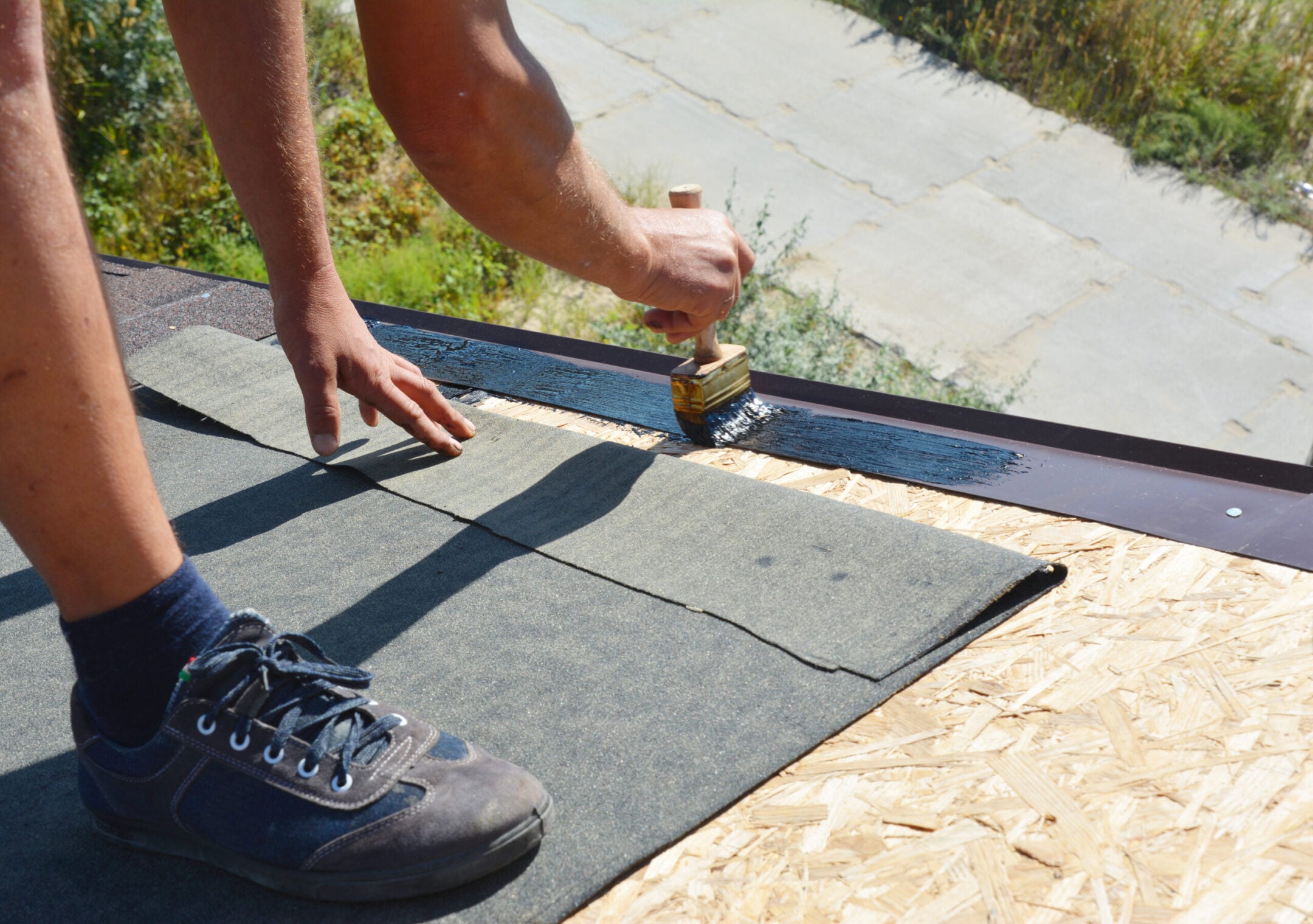 Roofer gluing waterproof membrane