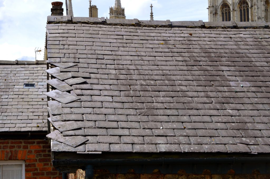 storm damage roof repair Loose slates on a house roof
